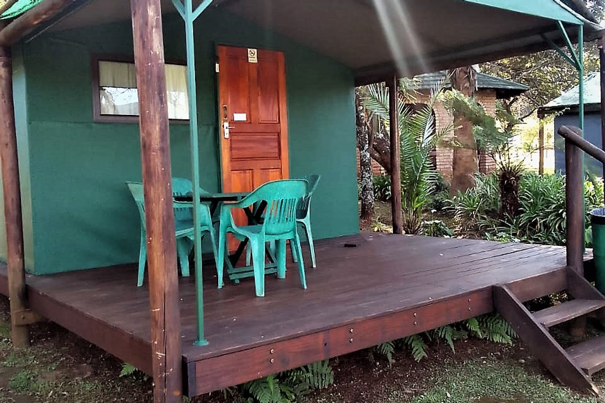 Tent on a raised wooden platform with patio table and chairs