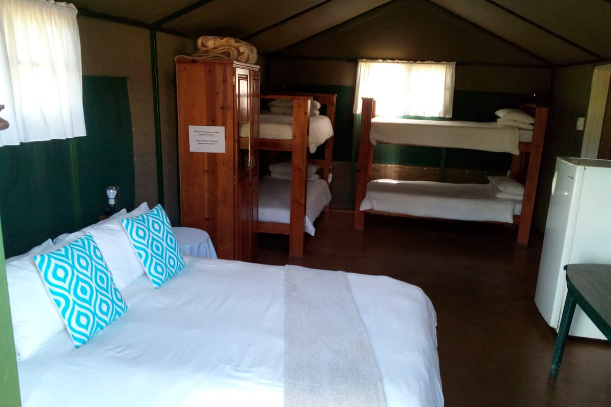 Double bed with linen inside a safari tent