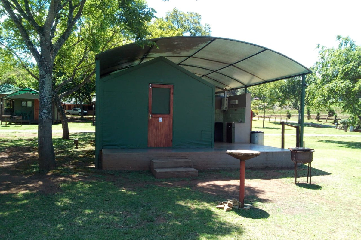 Caravan parked on a level grassed site at Sabie River Camp
